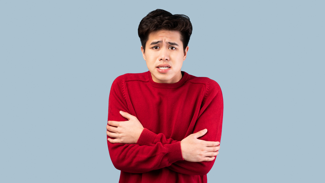 Portrait of asian guy shivering, trembling and feeling cold