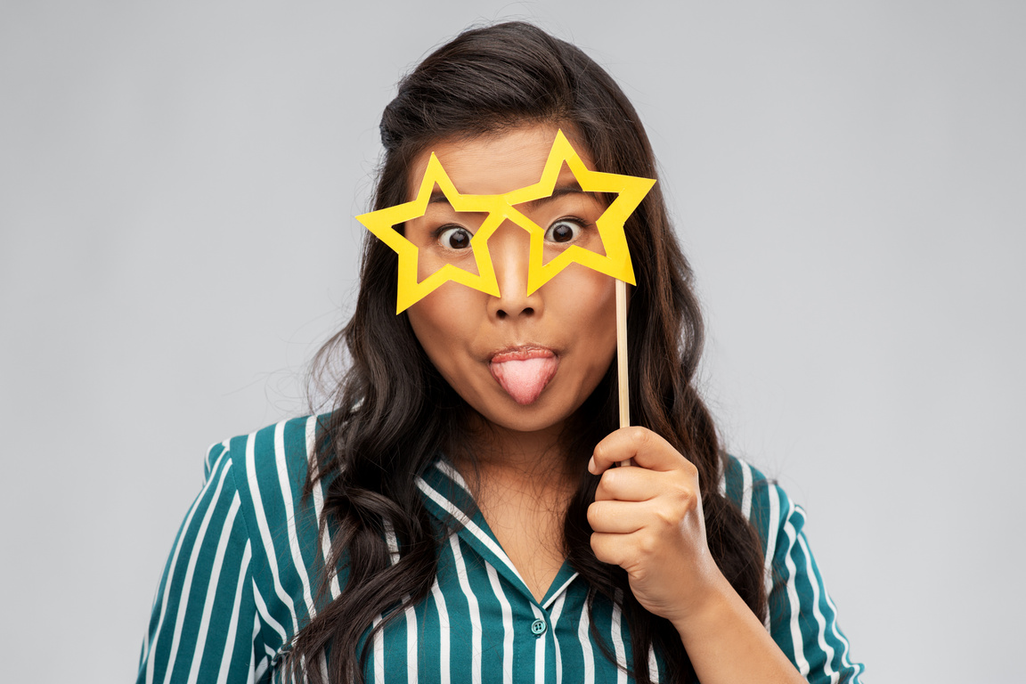 Happy Asian Woman with Star-Shaped Party Glasses